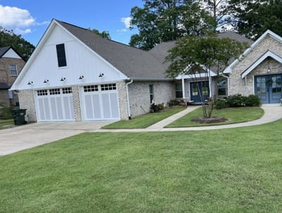 White farmhouse-style home with a freshly mowed lawn